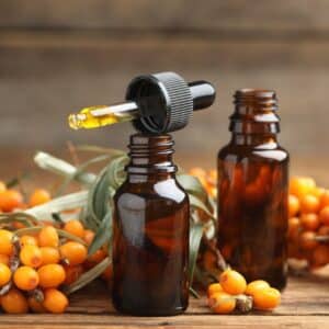Natural,Sea,Buckthorn,Oil,And,Fresh,Berries,On,Wooden,Table